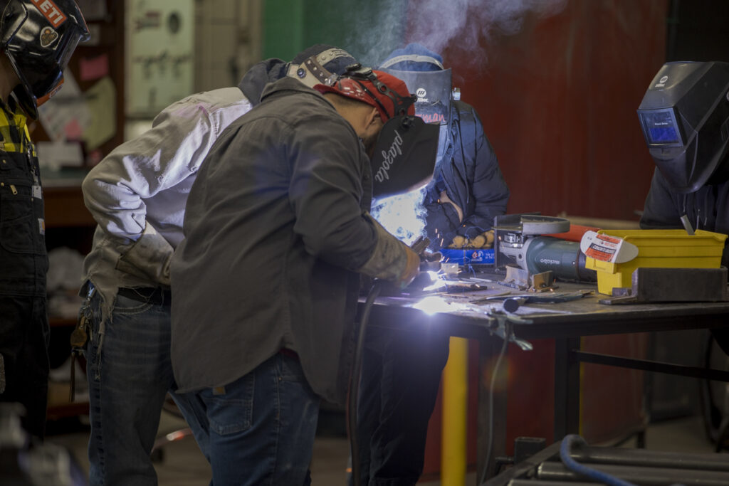 Welding Students Perform Cut with Sparks Flying in Welding Lab, Denver, CO