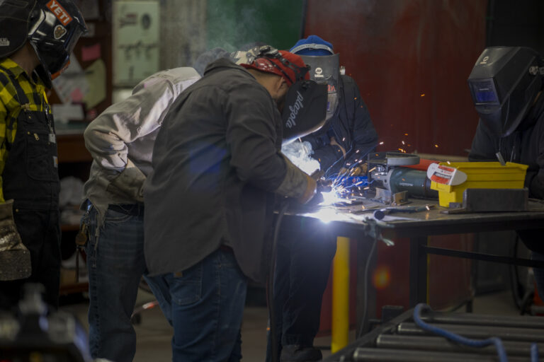 Welding Students Perform Cut with Sparks Flying in Welding Lab, Denver, CO