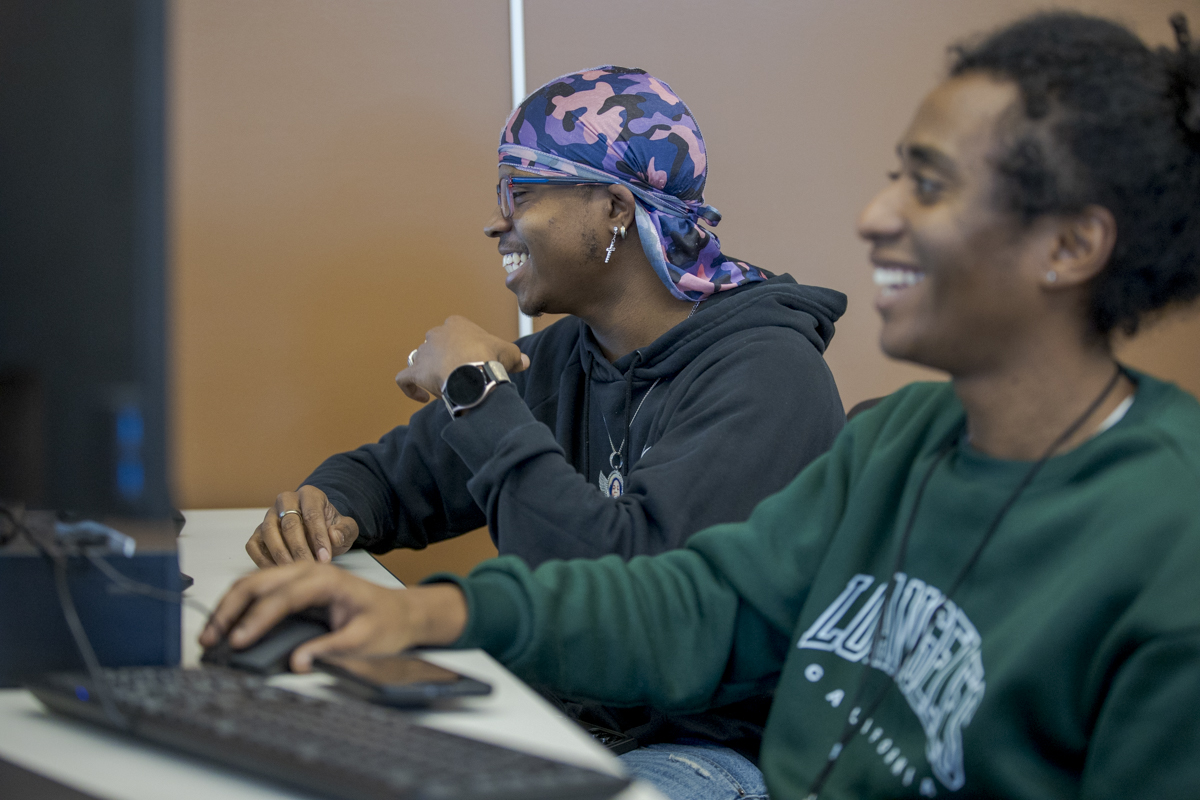 Two Computer Networking Students Smiling and Looking at Computer Screen in Denver, CO
