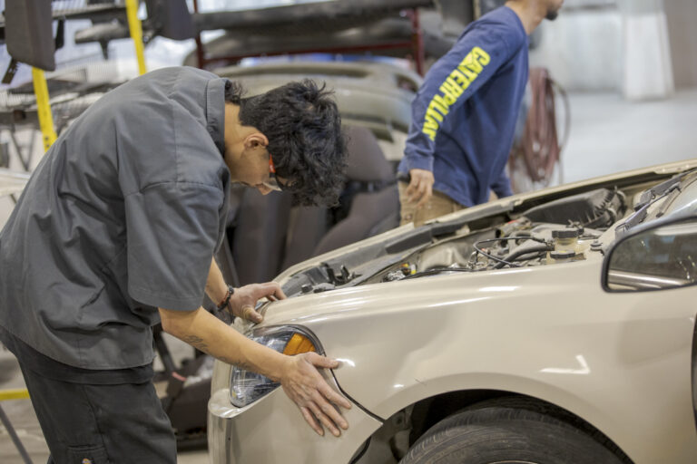 Male Automotive Collision Repair Student Working on Front End of Car in Denver, CO