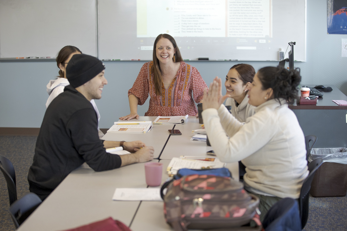 English Language Acquisition instructor working with group of students at desks