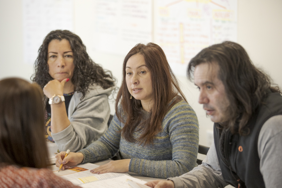 English Language Acquisition instructor working with group of students at desks