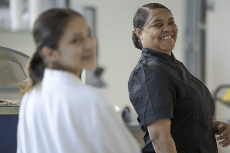 Two Female Culinary Arts Students Smile at Camera in Denver, CO