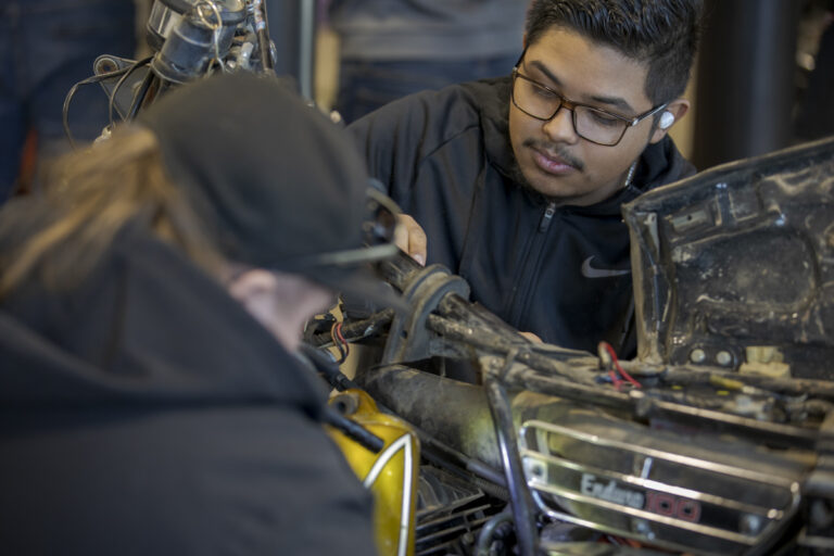 Two Male Automotive Service Students Working on Motorcycle in Denver, CO