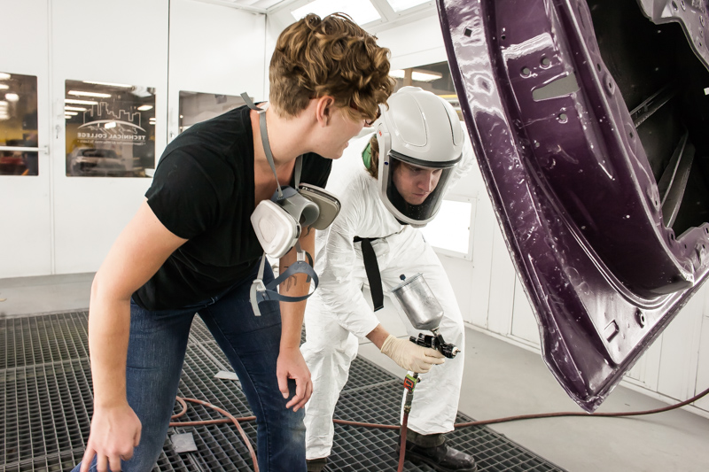 Two Male Automotive Collision Repair Students Painting Car Part in Denver, CO