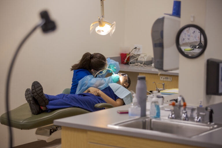 Dental Assisting student performs test teeth cleaning on a fellow student in Denver, CO