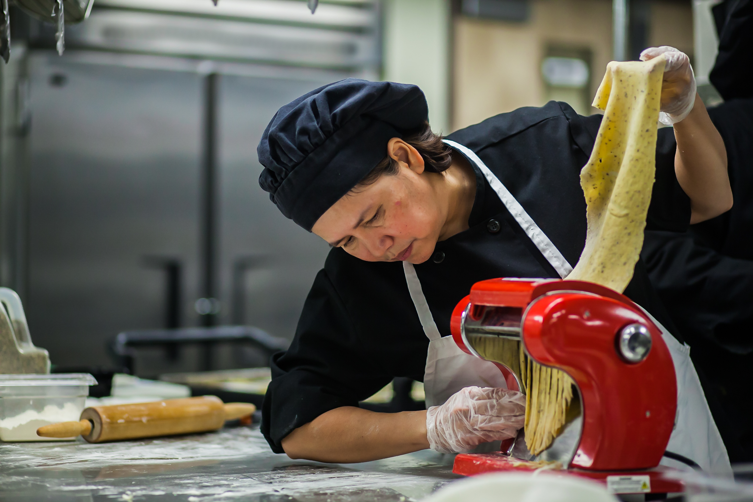 Female Culinary Arts Student Processes Homemade Pasta Dough for Emily's Cafe in Denver, CO