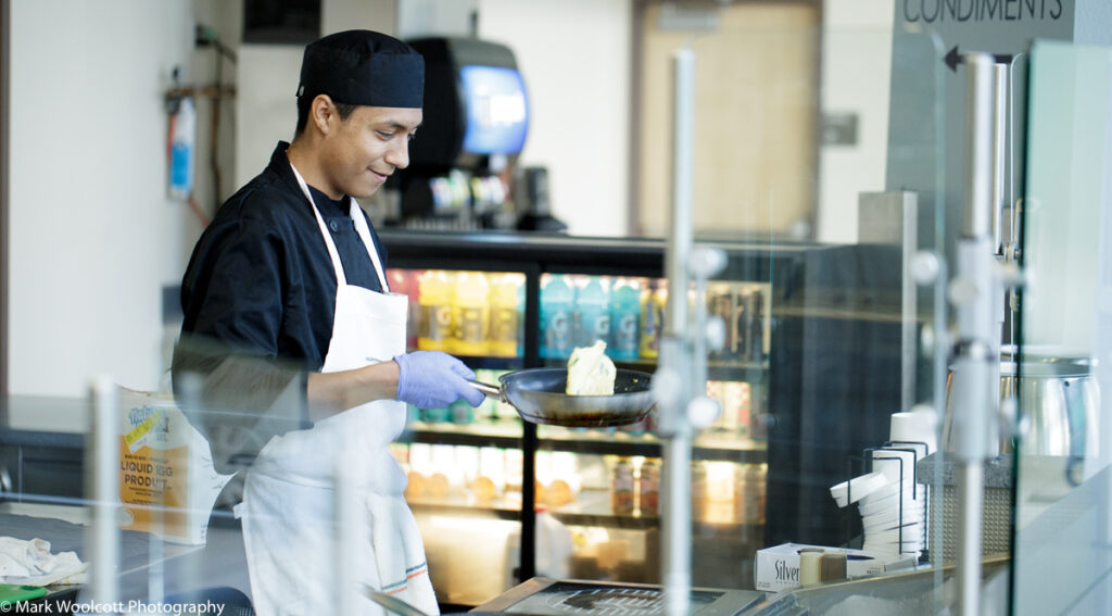 Male Culinary Arts Student Flips Omelette in Emily's Cafe in Denver, CO