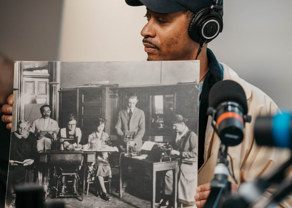 Multimedia and Video Production Student Holds Historical Photograph of Opportunity School Classroom for Video Podcast Recording in Denver, CO