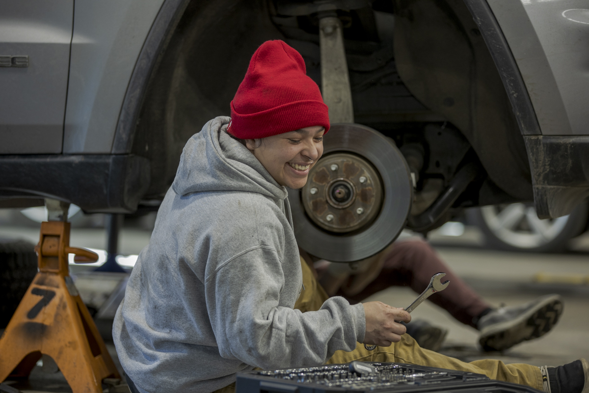 Female Automotive Service Student Working on Wheel of Car in Denver, CO