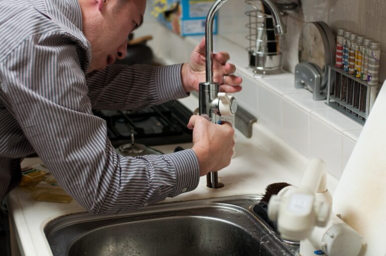 Stock image - plumber working on kitchen sink