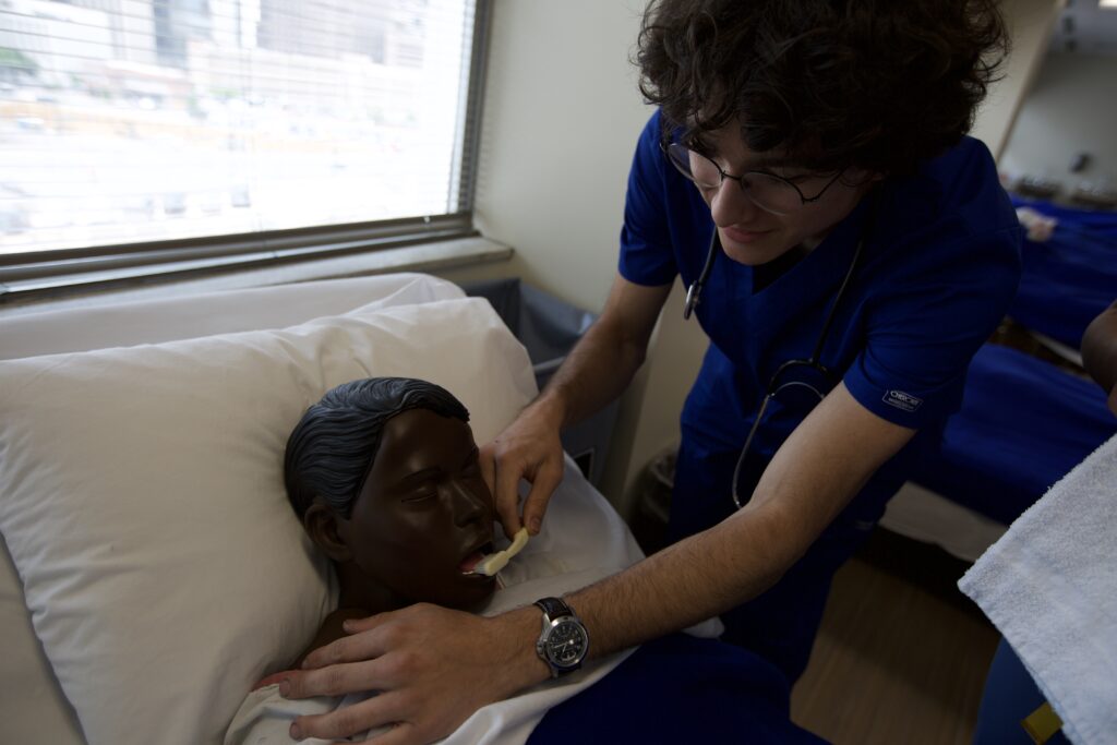 Nursing student observing mannequin patient