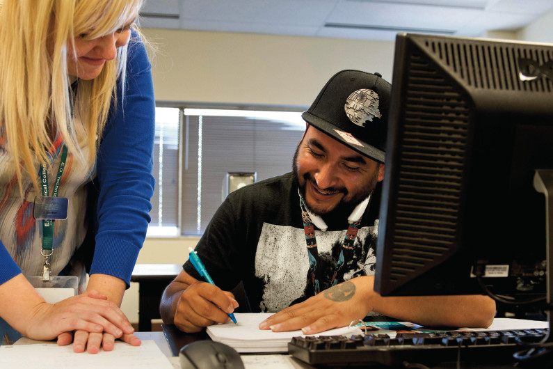 High School Equivalency instructor smiles with student while preparing for the GED