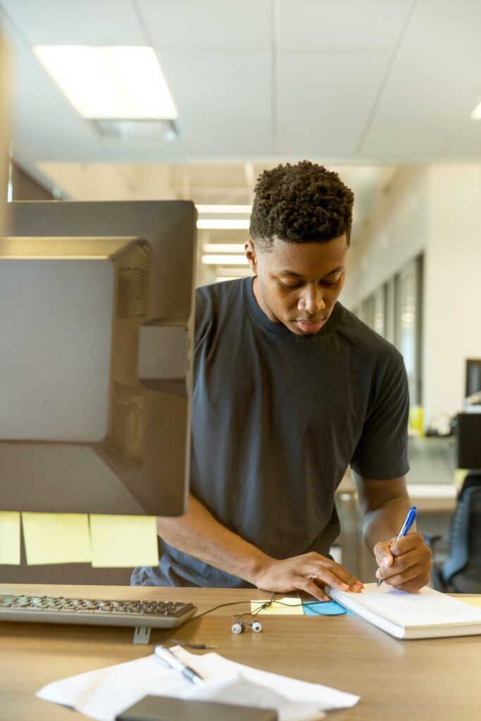 Student using computer and taking notes