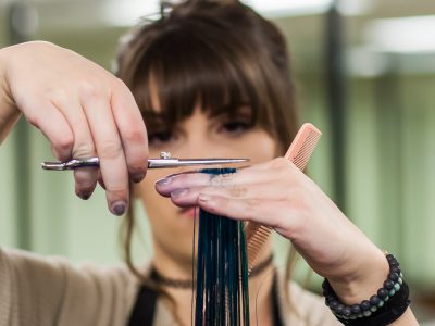 Female Cosmetology Student Cutting Client's Hair in Denver, CO