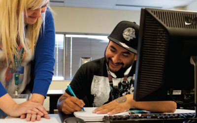 DENVER - OCT. 24: Emily Griffith Technical College high school equivalency instructional specialist Laura Blom, 33, left, smiles with student Luis Carrillo, 34, right, while checking Luis's pre-algebra work as part of an eight-week course for adult students studying to take GED tests.  (Photo by Andy Colwell for The Denver Post)
