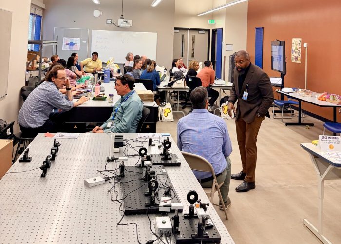 Participants in QCaMP—a professional development program introducing K-12 educators to quantum information science—at Emily Griffith Technical College’s Osage campus. Dr. Charles Tahan (standing, right) leads the session, while Dr. Boaz Nash (seated, second from left) will head the college’s upcoming Quantum Technician program.