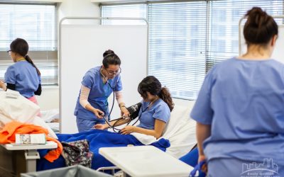 Nurse Assistant students practice using stethoscope and blood pressure cuff in Denver, CO