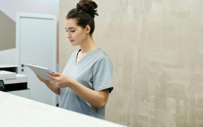Professional receptionist in uniform using a tablet in a modern office setting.